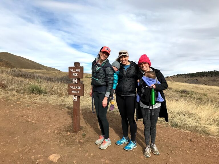 Three women outside hiking. One pregnant woman, one with a new born and one with toddler